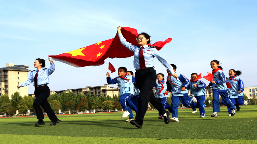 在新疆，卡卡湾
新源县税务局开展“税务蓝”牵手“红领巾”税收宣传活动，图为税务干部与少先队员们共同庆祝中华人民共和国成立76周年。韦苗苗摄.jpg